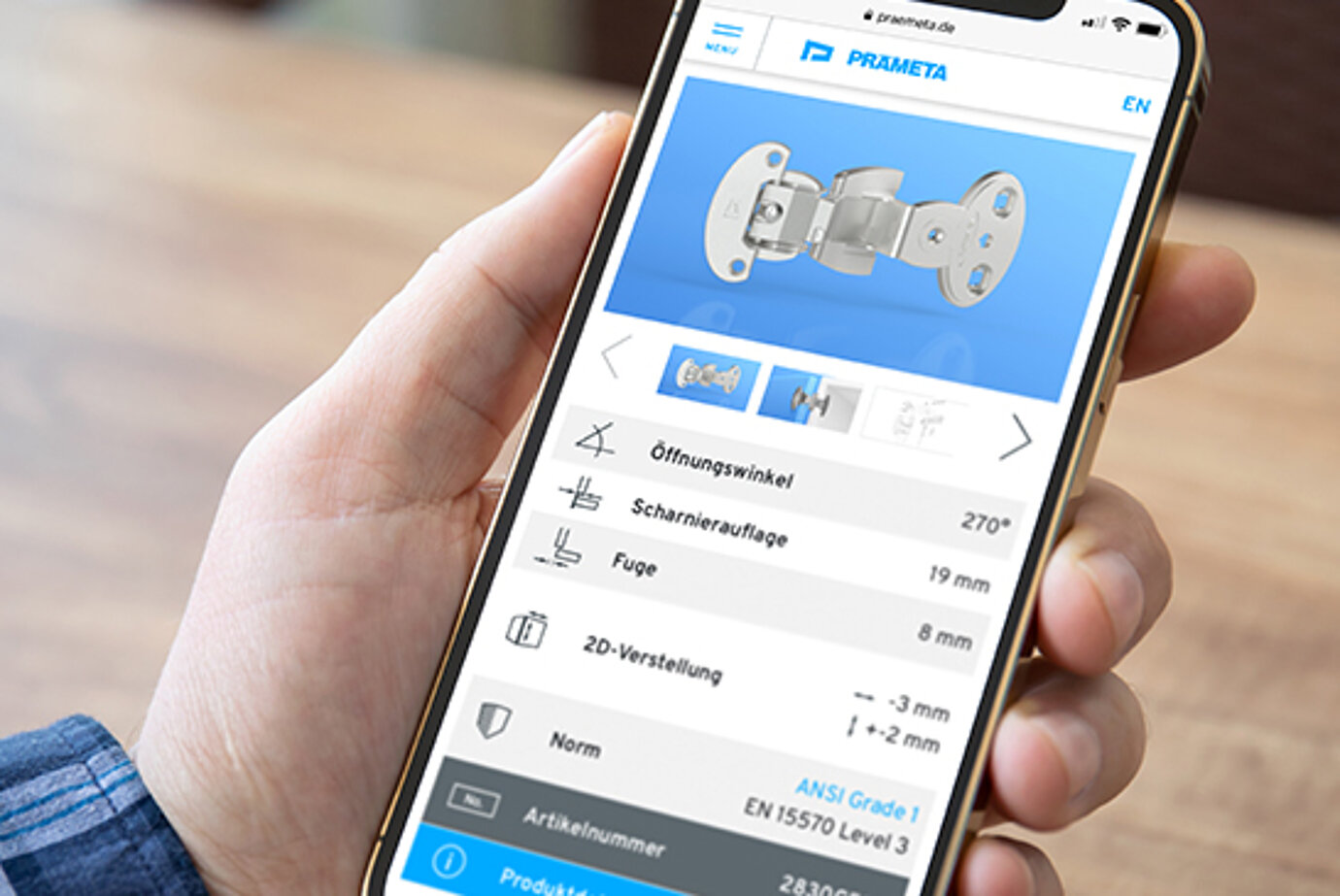 Eine positive User Experience erfüllt Nutzer-Bedürfnisse und zahlt auf das Marken-Image ein. Smartphone mit der Website des Scharnier Spezialisten PRÄMETA in der Hand eines Kunden.