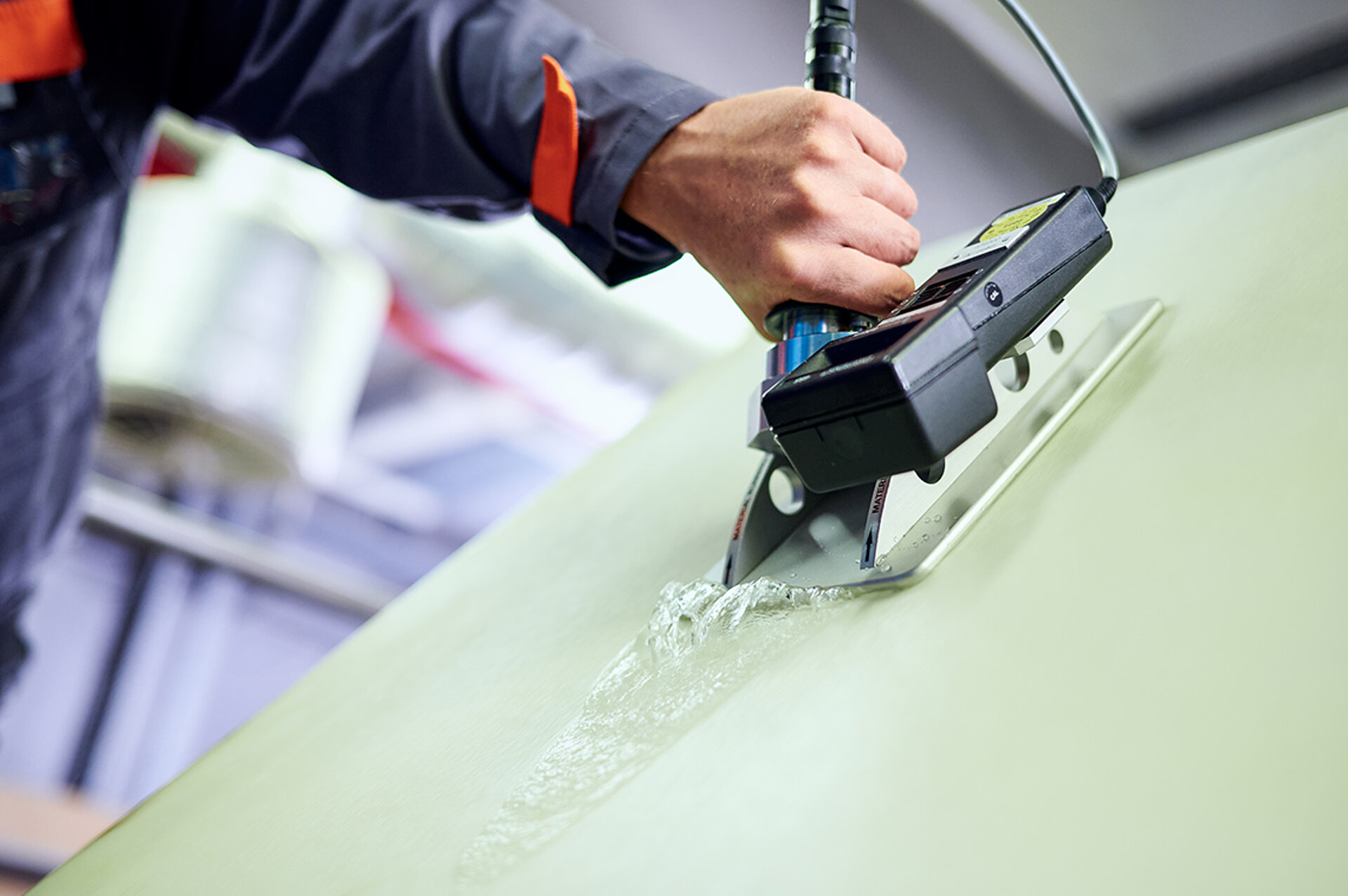 Ein Mitarbeiter des technischen Services von Heimbach (TASK) nimmt eine Spannungsmessung vor, um die Gleichmäßigkeit der Zugspannung des Materials zu prüfen. Ein Mitarbeiter des technischen Services von Heimbach misst die Spannung der Bespannung einer laufenden Papiermaschine.