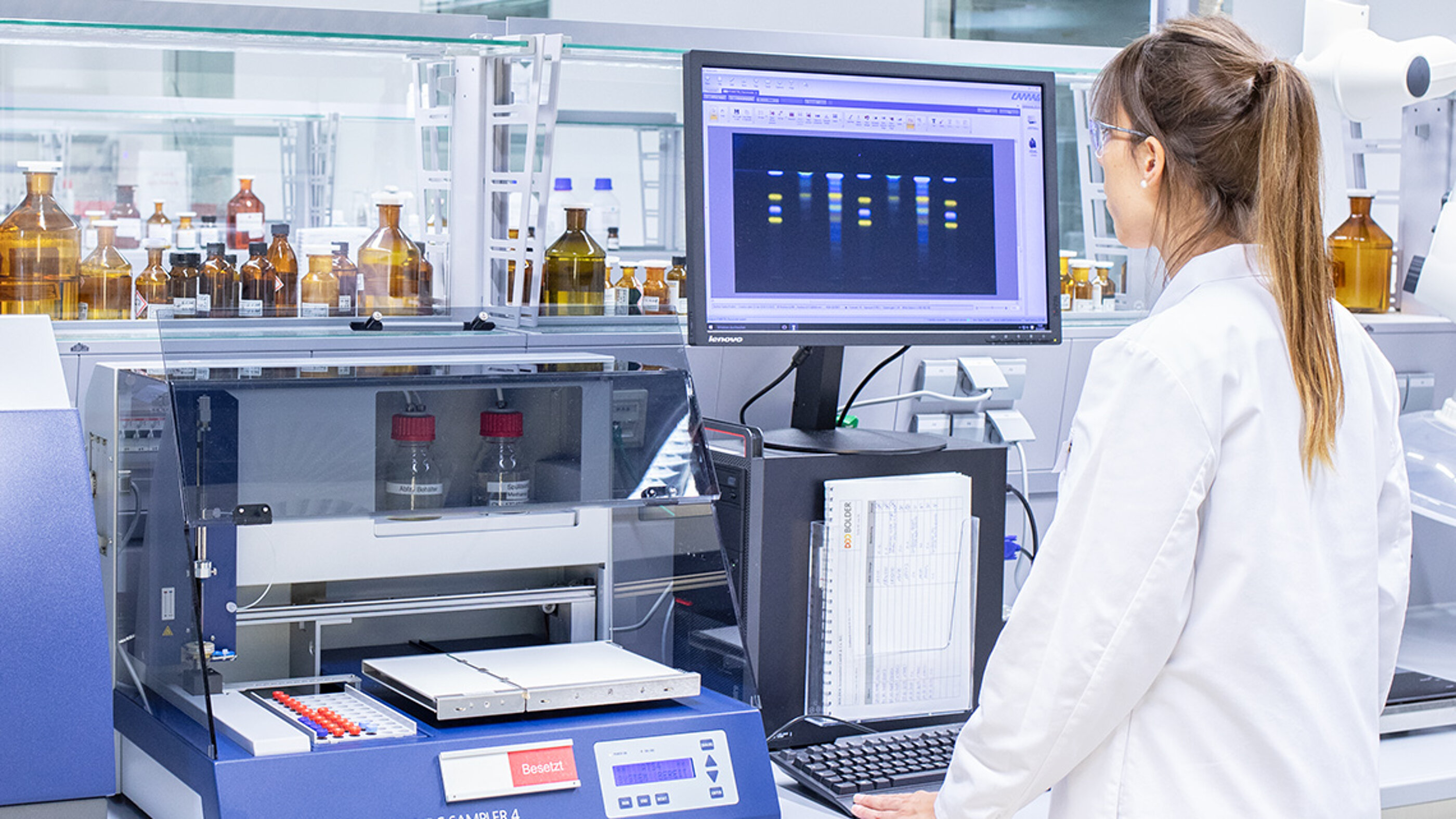 Qualitätsskontrolle und Qualitätssicherung sind wesentliche Bestandteile der Good Manufacturing Practices (GMP) und werden in der Marken-Bildwelt abgebildet. Die BOLDER Arzneimittel Bildwelt zeigt eine Laborantin, die mit einem Gerät die Qualität einer Produktprobe kontrolliert.