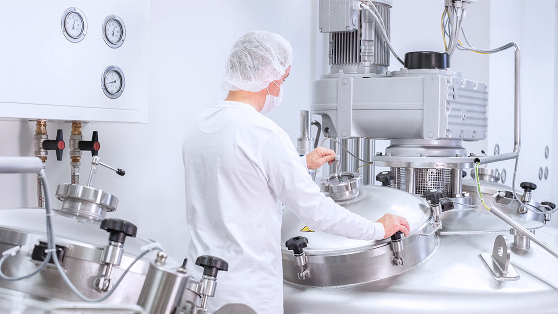 Die Marken-Bildwelt gibt einen Einblick, wie unter Reinraum-Bedingungen die Gießmasse zur Pastillen-Produktion hergestellt wird. Die BOLDER Arzneimittel Bildwelt zeigt einen Mitarbeiter, der einen Kessel mit Gießmasse für die Pastillen Produktion verschließt.
