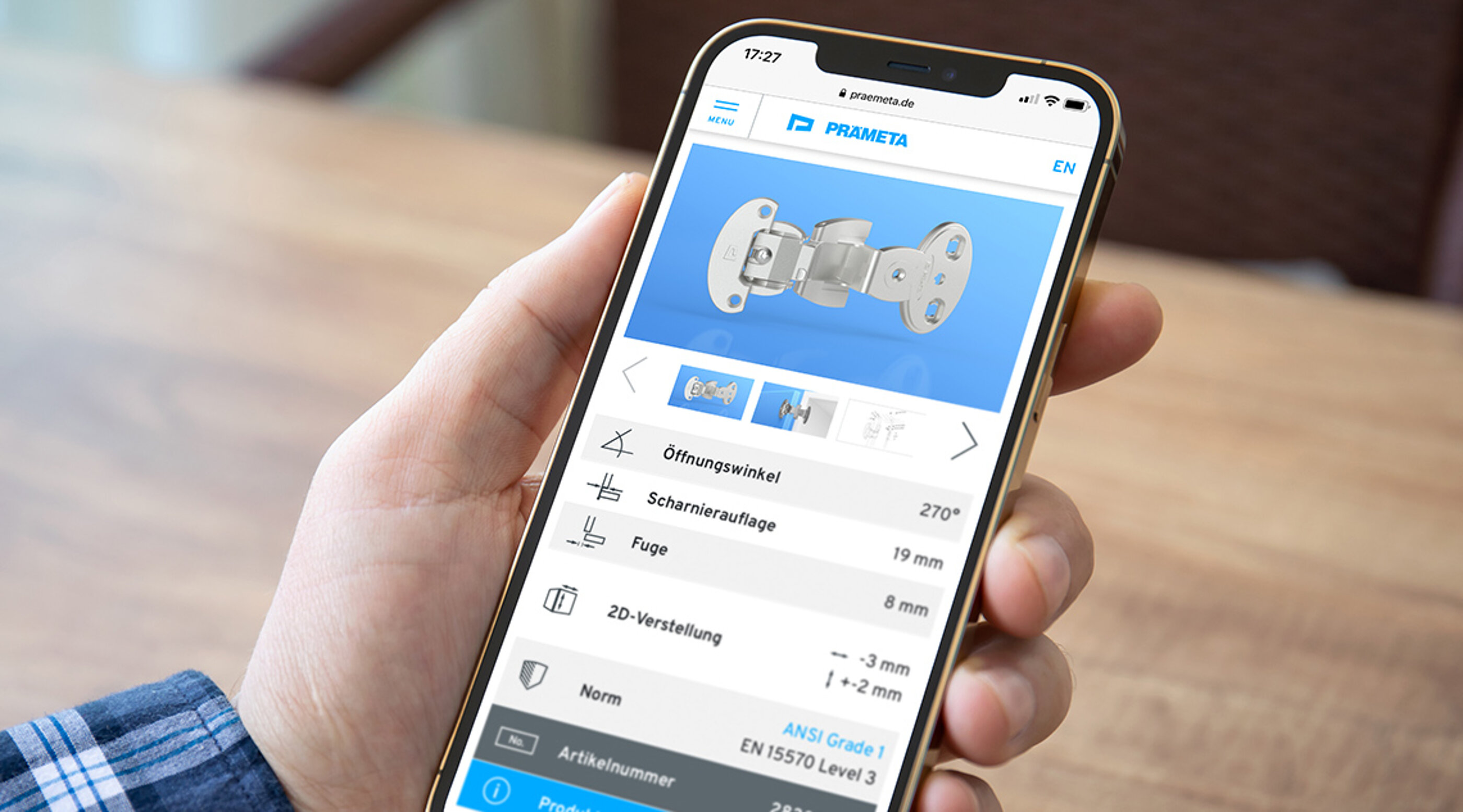 Eine positive User Experience erfüllt Nutzer-Bedürfnisse und zahlt auf das Marken-Image ein. Smartphone mit der Website des Scharnier Spezialisten PRÄMETA in der Hand eines Kunden
