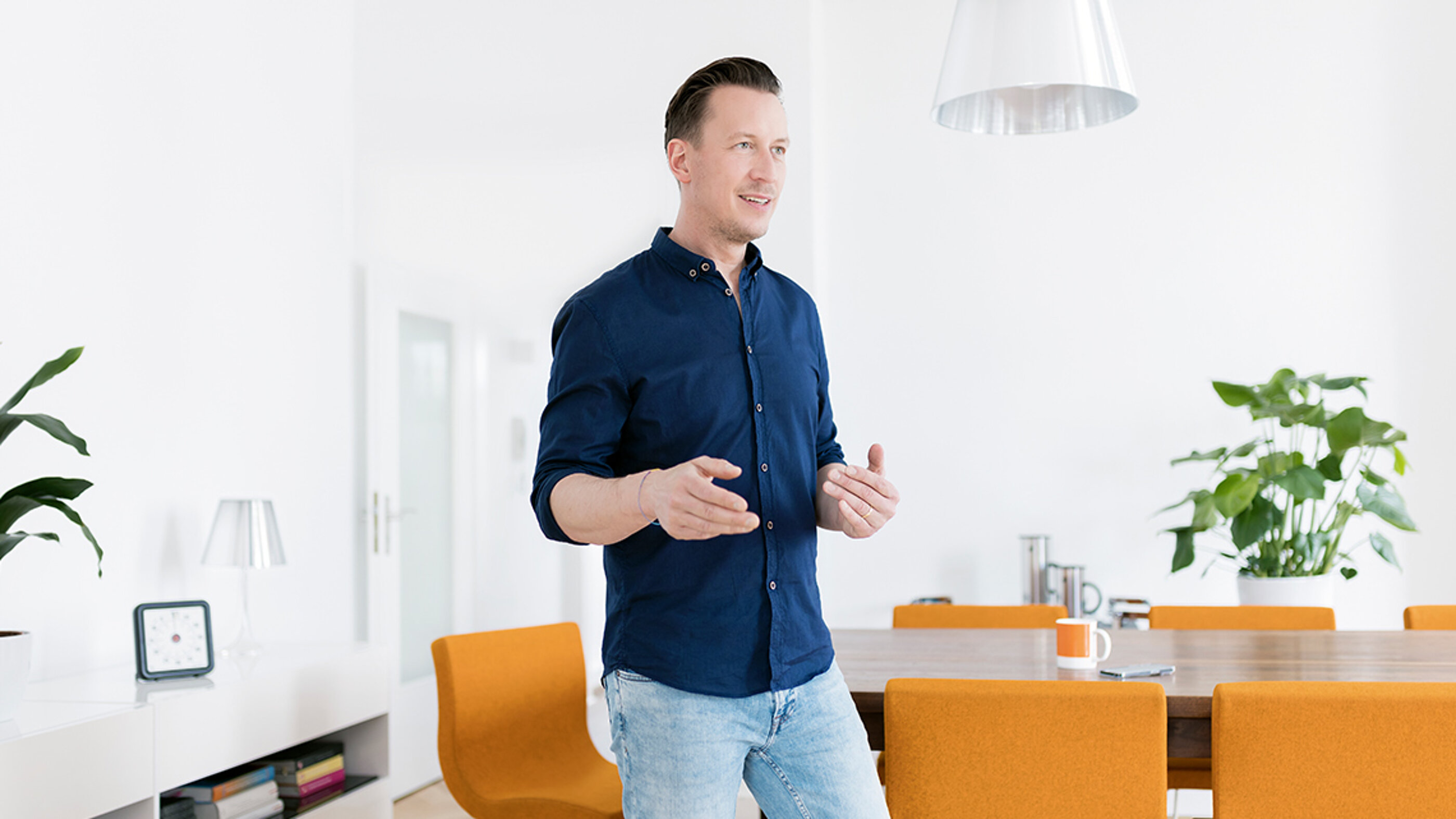 Carsten Brandt berät Sie zu Fragen rund um Marken-Positionierung, -Aufbau und -Führung, entwickelt die Strategie und kreiert das lebendige Markenbild. Carsten Brandt von Freunde der Klarheit steht im Konferenzzimmer.