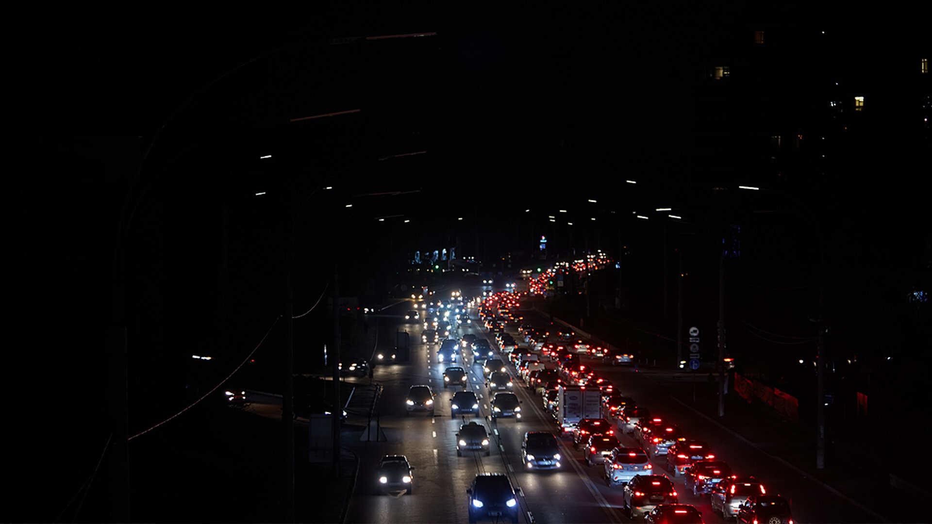 Ein flächendeckender Stromausfall in der Stadt sorgt u.a. für Dunkelheit, die allein durch Autoscheinwerfer auf den Straßen aufgehellt wird.