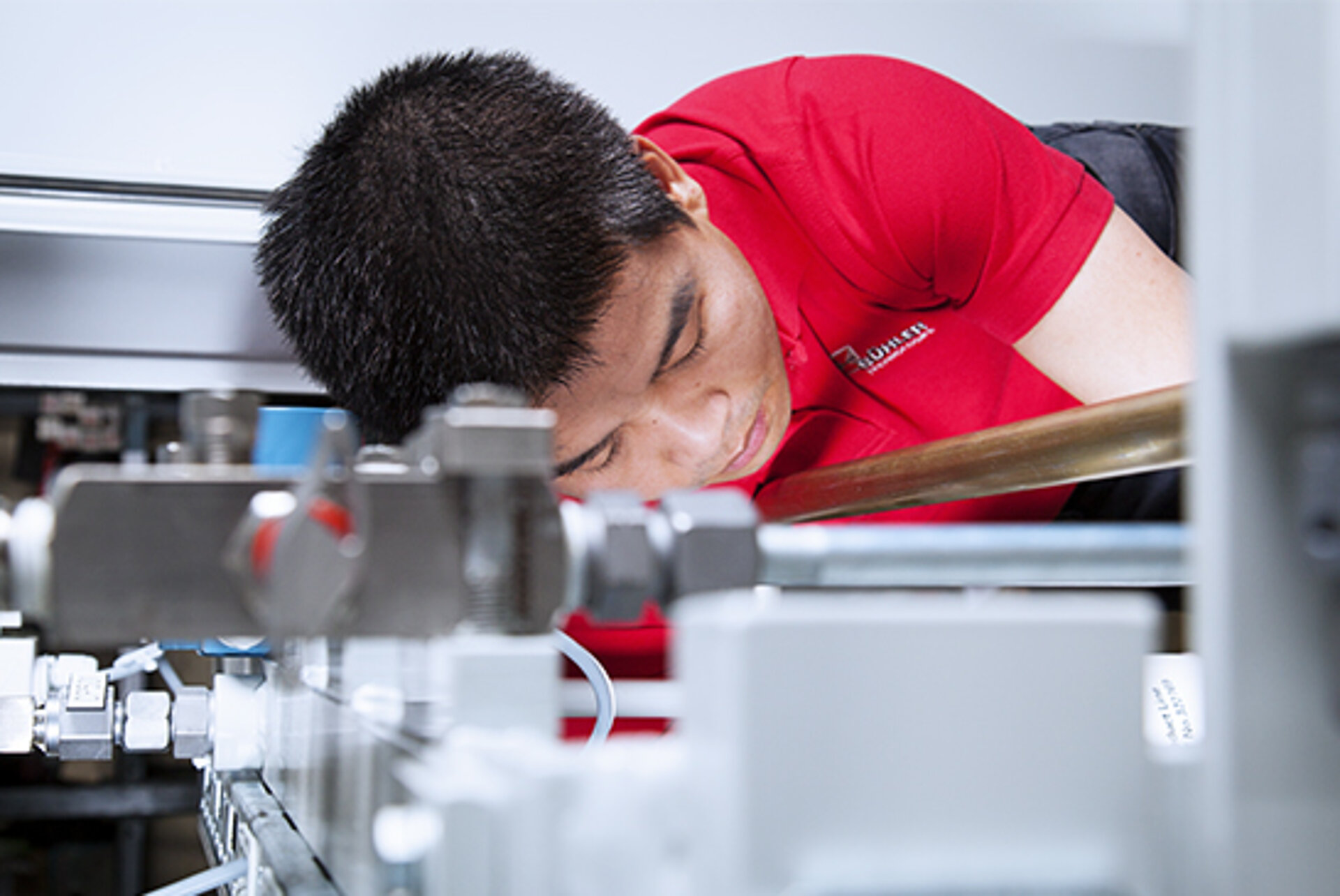 Ein BÜHLER Technologies Monteur baut Messtechnik in eine Anlage ein.